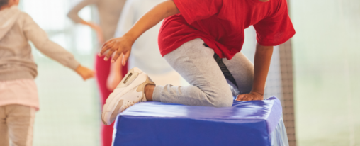 Kind auf Schaumstoff Baustein im Kinderturnen